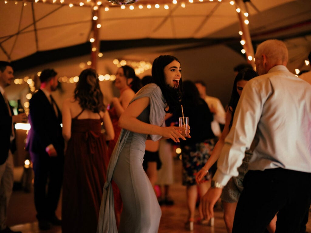 Guests dancing on the dancefloor in a tipi marquee outside The Sheriffs at White Heron Estate wedding venue Herefordshire