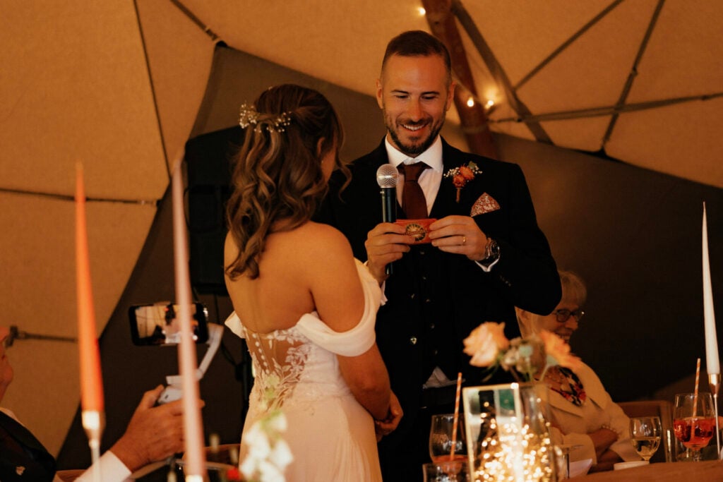 Bride and Groom reading speeches in a tipi marquee outside The Sheriffs at White Heron Estate wedding venue Herefordshire