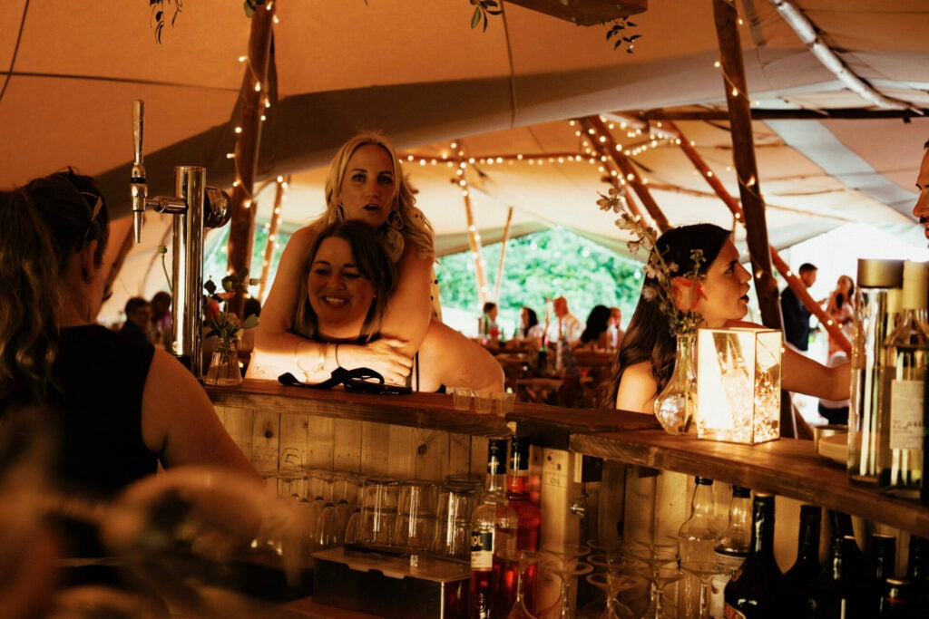 Guests enjoying a party in a tipi marquee outside The Sheriffs at White Heron Estate wedding venue Herefordshire